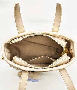 Top-down macro view of beige tote bag interior with brown fabric lining and inner pocket