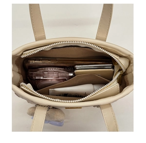 Vertical top view showing interior capacity and inner pocket of the beige bucket bag