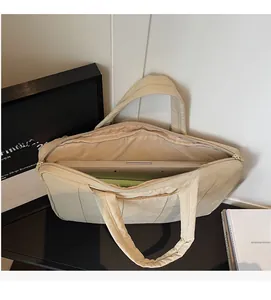 Internal view of a beige quilted laptop bag showing large storage capacity and zipper