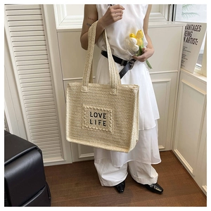 Détail du sac cabas en paille tissée avec broderie LOVE LIFE et doubles anses pour l'été