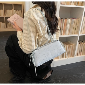 Détail du sac baguette bleu clair avec motifs étoilés et cordons de serrage latéraux