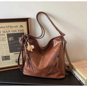 Detailed macro of brown leather texture and decorative diagonal zippers on tote bag