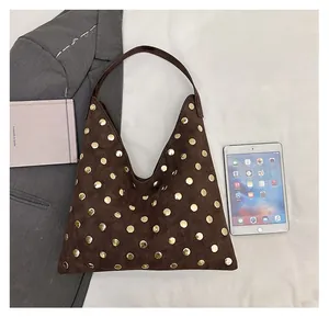Large vintage dark brown suede tote bag with metal studs compared next to an iPad