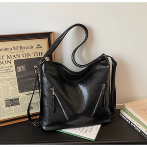 Detail of black vintage tote bag with parallel zippers and textured faux leather finish
