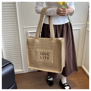 Détail du sac cabas en paille crochetée avec broderie LOVE LIFE et anses renforcées