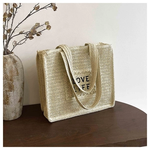 Détail de la texture crochet ajourée et du patch LOVE LIFE sur le sac en paille