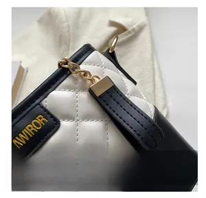 Detailaufnahme der gesteppten weißen Ledertasche mit schwarzem Rand und Gold-Logo