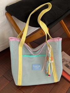 Sac fourre-tout en maille bleue avec poignées jaunes et breloque colorée d'été