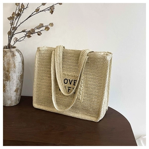 Détail du sac cabas en paille tissée avec patch brodé LOVE LIFE et texture naturelle