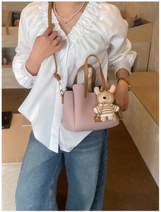 Chic lotus pink tote bag with bear charm shown in a cozy cafe setting for women