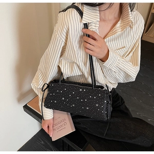 Détail d'un grand sac baguette noir avec imprimé étoiles blanches et fermeture éclair