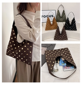 Detail of vintage suede hobo bag with gold metal studs and spacious interior layout