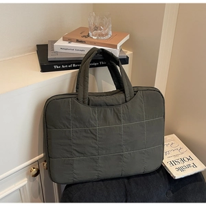 Close-up of olive green quilted laptop bag showing premium stitching and nylon texture