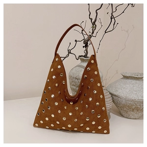 Detailed macro view of the brown suede tote with decorative gold metal rivets decoration