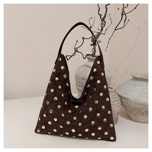 Close-up of vintage dark brown suede hobo bag with detailed golden rivet studs