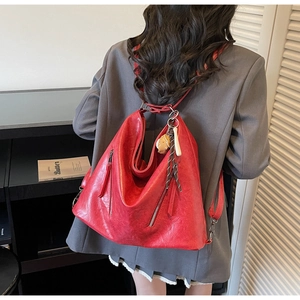 Red soft leather backpack featuring a slouchy dumpling shape and cute biscuit charm detail