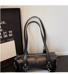 Detailansicht der schwarzen Zylindertasche mit Silberreißverschluss und glatter Ledertextur