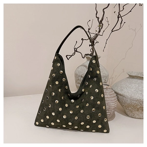 Detailed macro view of retro green suede tote bag with golden metal stud decorations