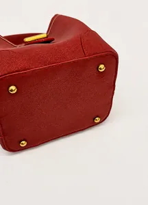 Detail der roten Beuteltasche aus Leder mit vier schützenden Metallfüßen am Boden