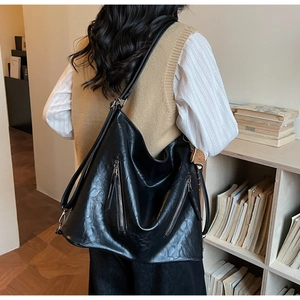 Close-up of vintage black PU leather shoulder bag showing texture and large capacity size