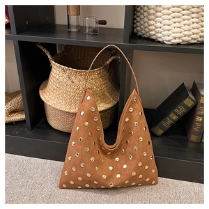 Detail of vintage brown suede tote bag featuring evenly distributed gold stud accents