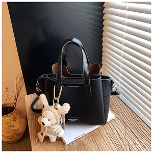 Detail of lychee pattern leather handbag with cute teddy bear charm andMQIER brand label