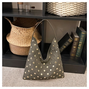 Detail of olive green suede hobo bag featuring gold rivet studs in a boho style