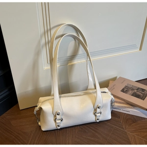 Detailansicht der weißen Leder-Schultertasche auf dunklem Fischgrät-Holzbodenbelag