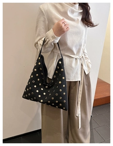 Detail view of black vintage hobo bag featuring gold rivet accents and soft matte leather