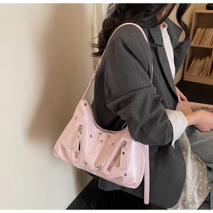 Detail of pink faux leather hobo bag featuring silver rivets and metal zip pockets