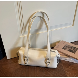 Detailansicht der cremeweißen zylindrischen Schultertasche mit silbernen Metallringen