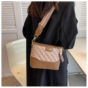 Detail der gesteppten Eimertasche mit braunem Leder und gewebtem Schultergurt