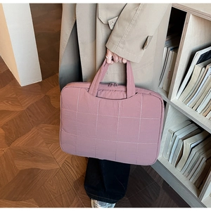 Detailed view of pink quilted laptop bag with soft fabric and dual zipper closure