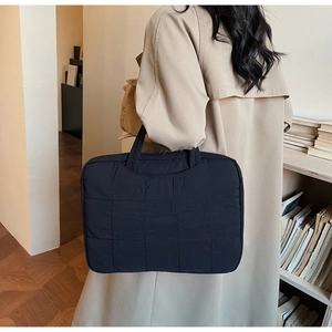 Close-up of black quilted laptop bag with padded texture for business commuting