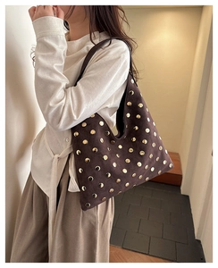 Detail of dark brown suede Hobo bag featuring golden rivets and premium texture