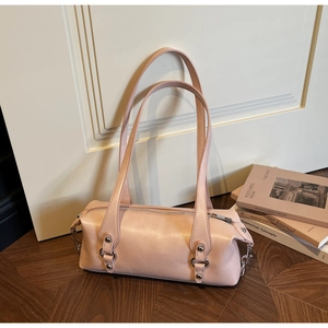 Detailansicht der hellrosa Boston-Tasche mit silbernen Nieten auf dem Holzfußboden