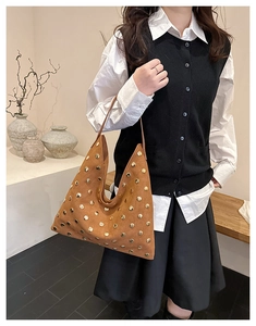 Close-up of brown suede tote bag with golden metal studs and vintage bohemian style detail