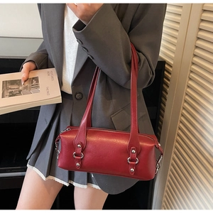 Detailansicht einer roten zylindrischen Schultertasche mit glänzender Lederstruktur