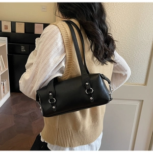 Detailansicht der schwarzen zylindrischen Schultertasche mit Nieten und Metallringen