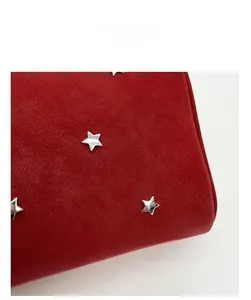 Vue macro détaillée de la texture givrée rouge et des rivets étoiles sur le sac à main