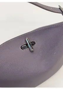 Detail of purple litchi grain leather bag with silver metal turn-lock and stitching