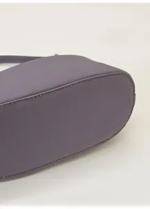 Detail shot of the lavender purple leather bag base showing precision stitching and texture
