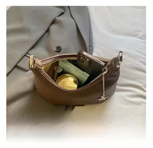 Dettaglio dell'interno di una borsa a mezzaluna in pelle marrone che mostra l'ampio spazio interno