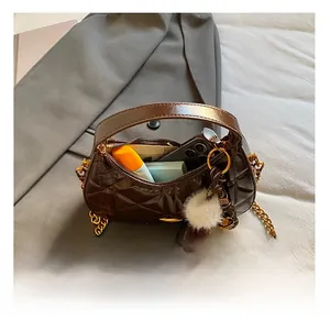 Macro shot of brown quilted leather handbag interior showing storage capacity and golden chain