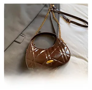 Detailed shot of brown quilted leather hobo bag with gold hardware and chain strap