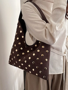Vintage dark brown suede tote bag with gold studs shown on shoulder for daily office style