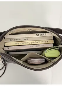 Top-down view of spacious bag interior with zipper pocket and branded fabric lining