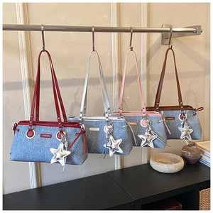 Dettaglio di quattro borse bowling in denim in rosso, argento, rosa e marrone con stelle