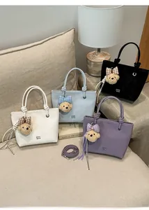 Collection of matte leather bucket bags in four colors with cute teddy bear charms
