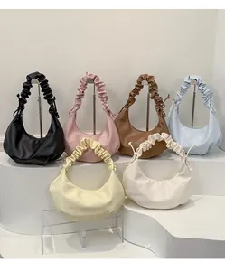 Detail view of stylish crescent dumpling bags with pleated handles in six various colors